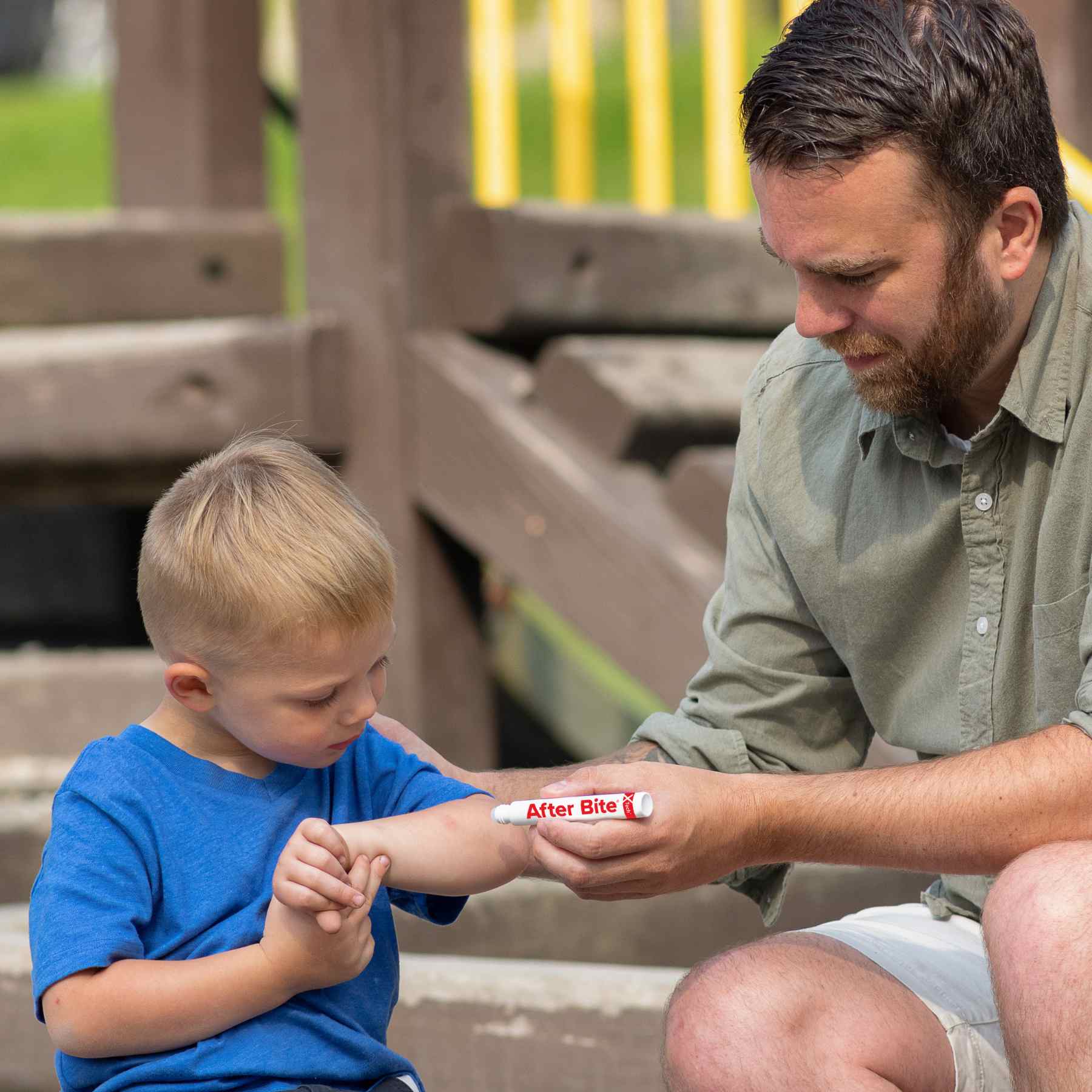 After Bite X Tech man applying to child in front of playground