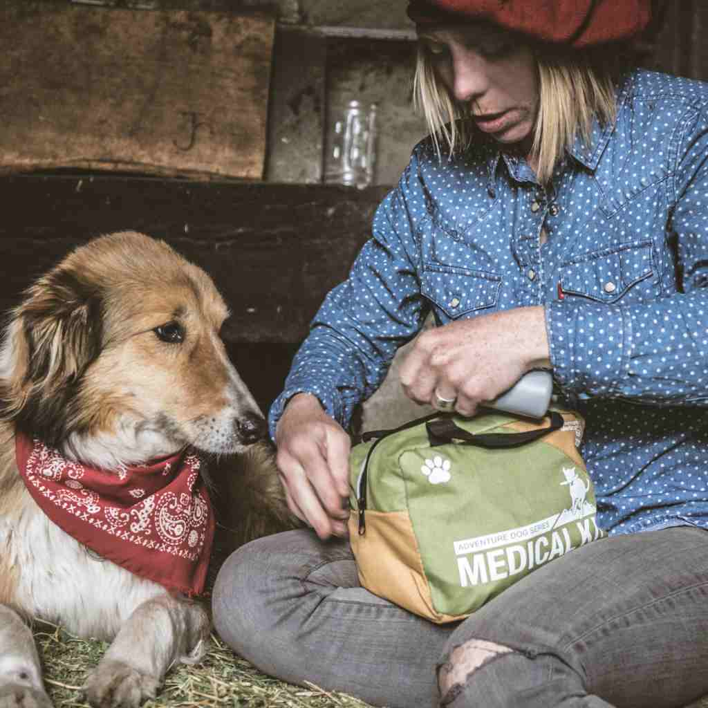 Adventure Dog Medical Kit - Workin' Dog woman opening kit next to dog with red bandana