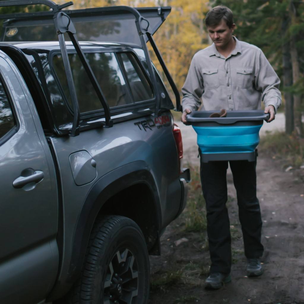 Flat Pack Gear Tub man carrying next to truck