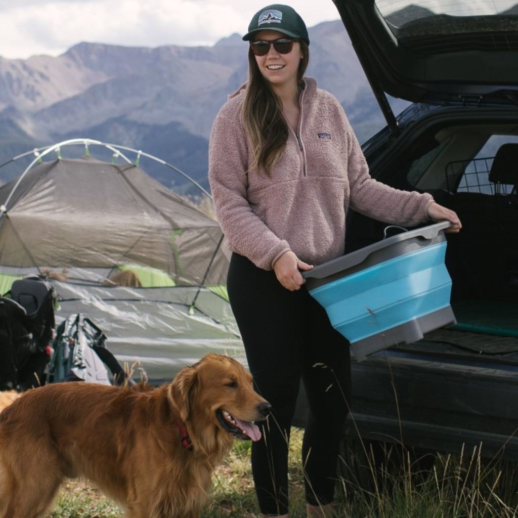 Flat Pack Gear Tub woman carrying near trunk next to dog